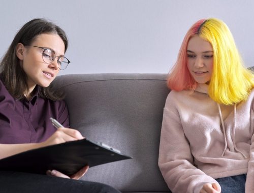 Woman psychologist working with teen girl. Visit and counseling of professional mental and social therapist. Psychology, teenager, problem, trauma, mental health of adolescents concept